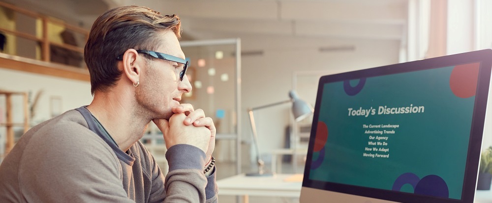 Man viewing a webinar on a computer monitor